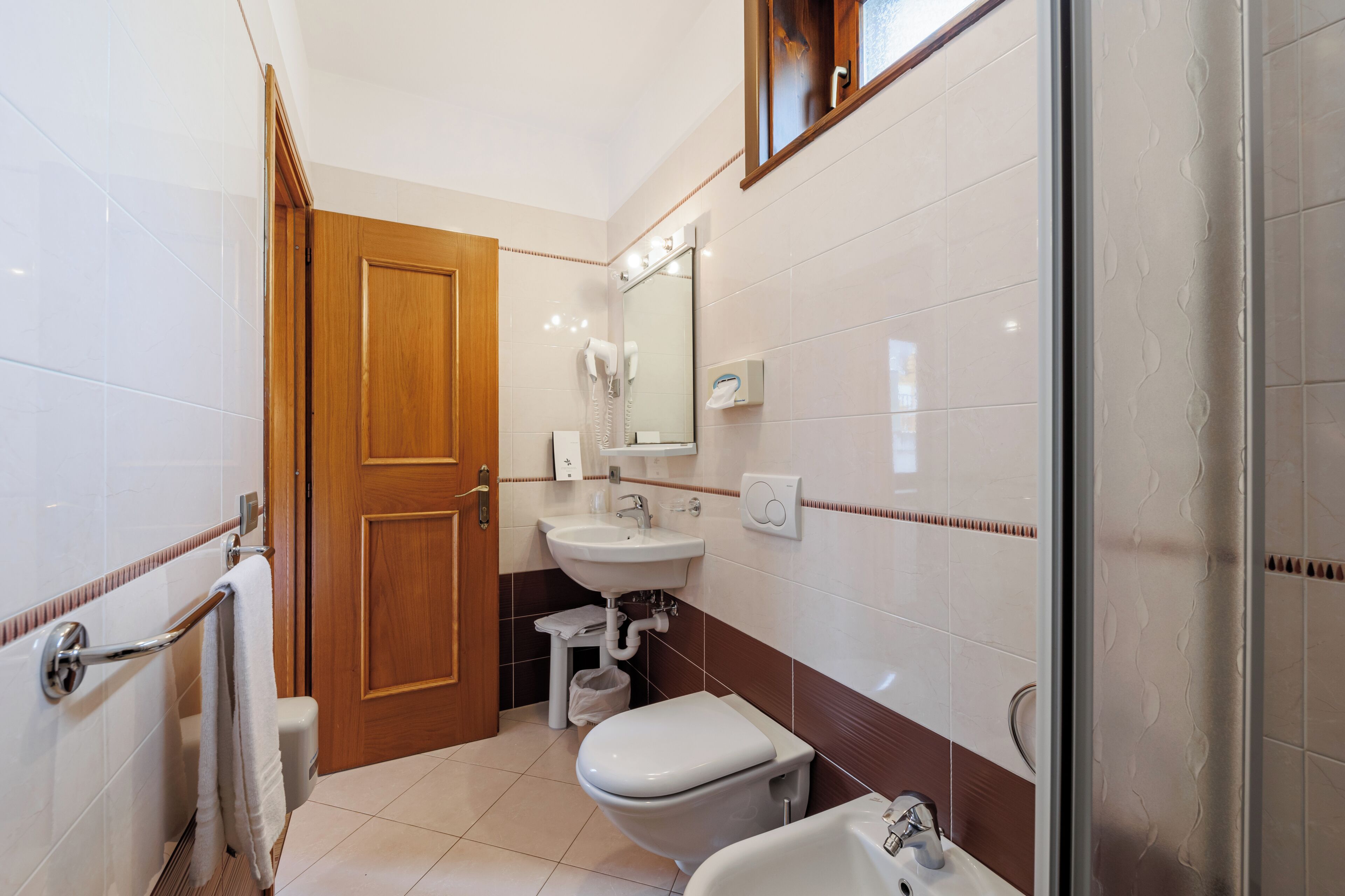 Un baño con inodoro, lavamanos y zona de ducha.
