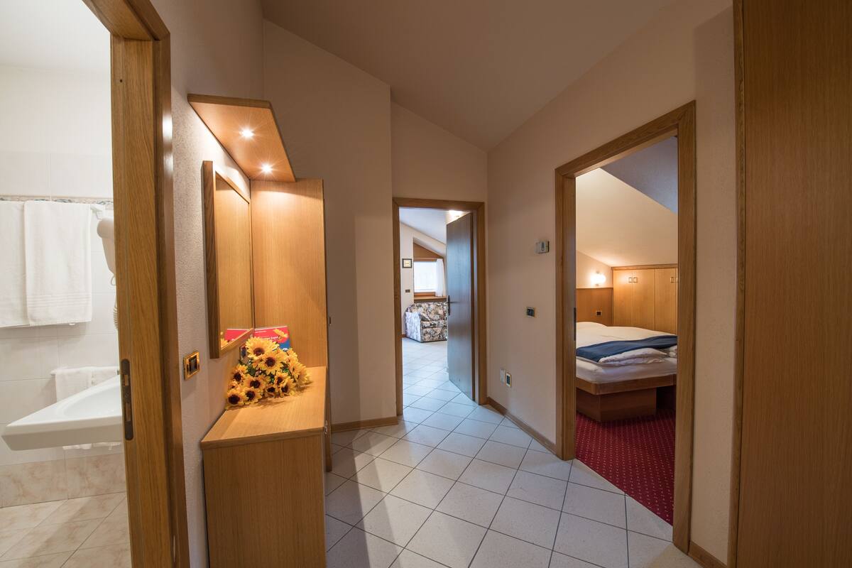 Una habitación de hotel con un escritorio de madera, una cama y un baño con bañera.