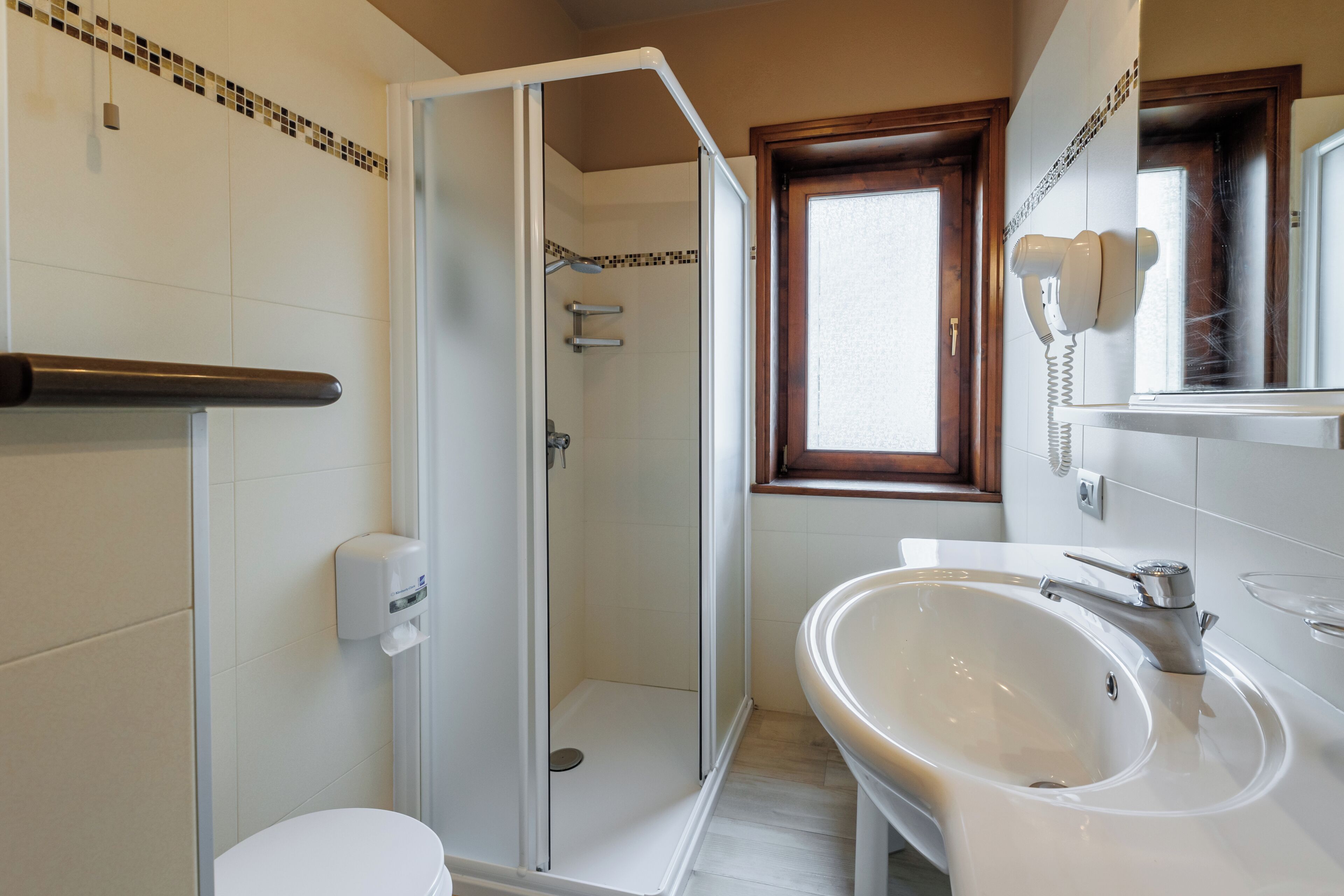 Une salle de bain équipée d’une douche, de toilettes, d’un lavabo et d’un téléphone.