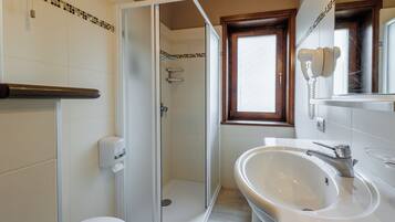 Une salle de bain équipée d’une douche, de toilettes, d’un lavabo et d’un téléphone.