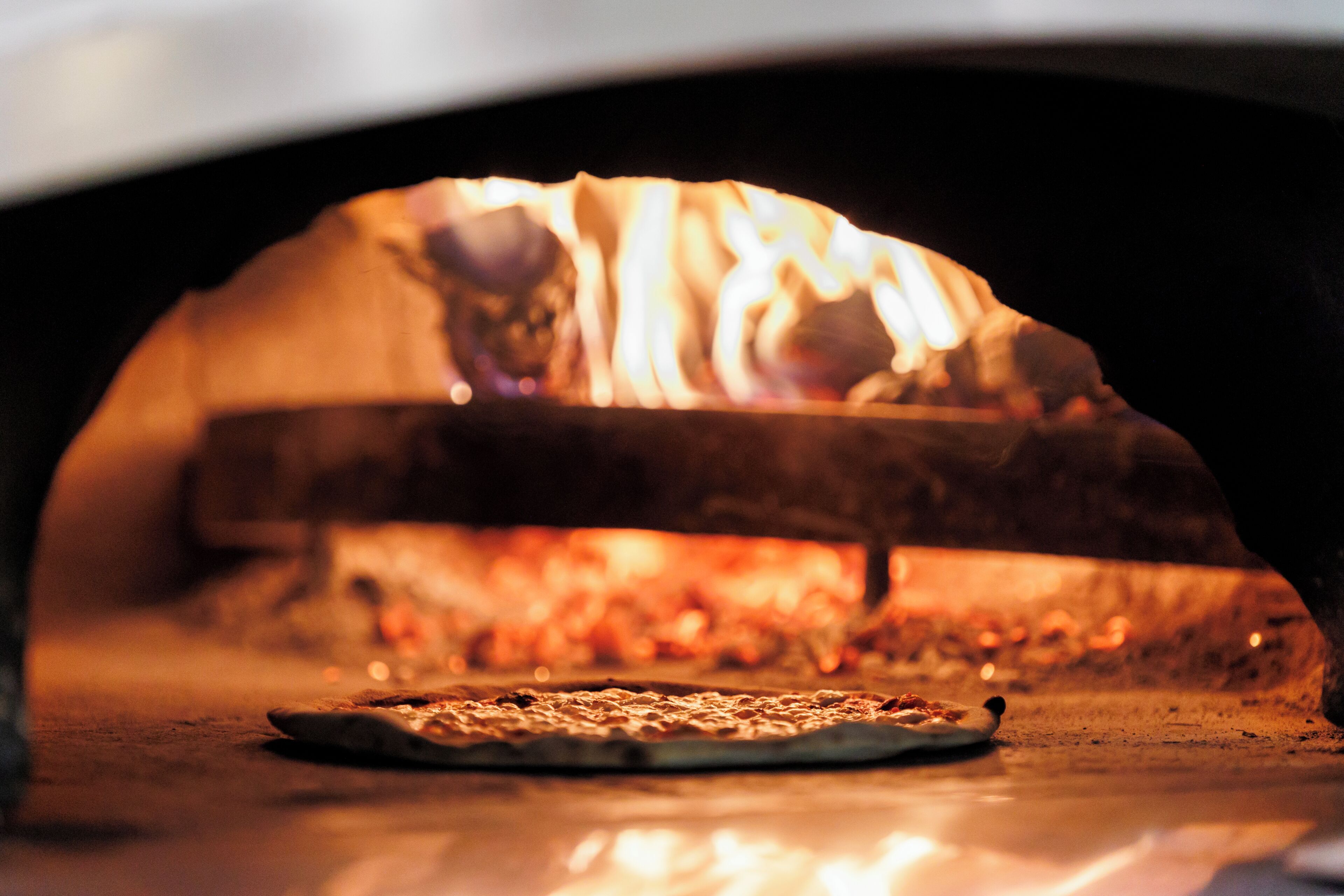 Une pizza cuite dans un four à bois.