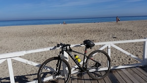 A bicycle parked on a wooden deck at a beach. - Palermo Rooms (Palermo)