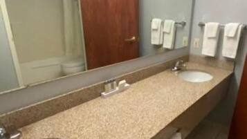 A bathroom with two sinks, a large mirror, and a wooden door.