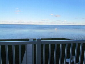 A view from a balcony overlooking a calm sea with a distant boat. - Lakeside Resort and Conference Center (Houghton Lake)