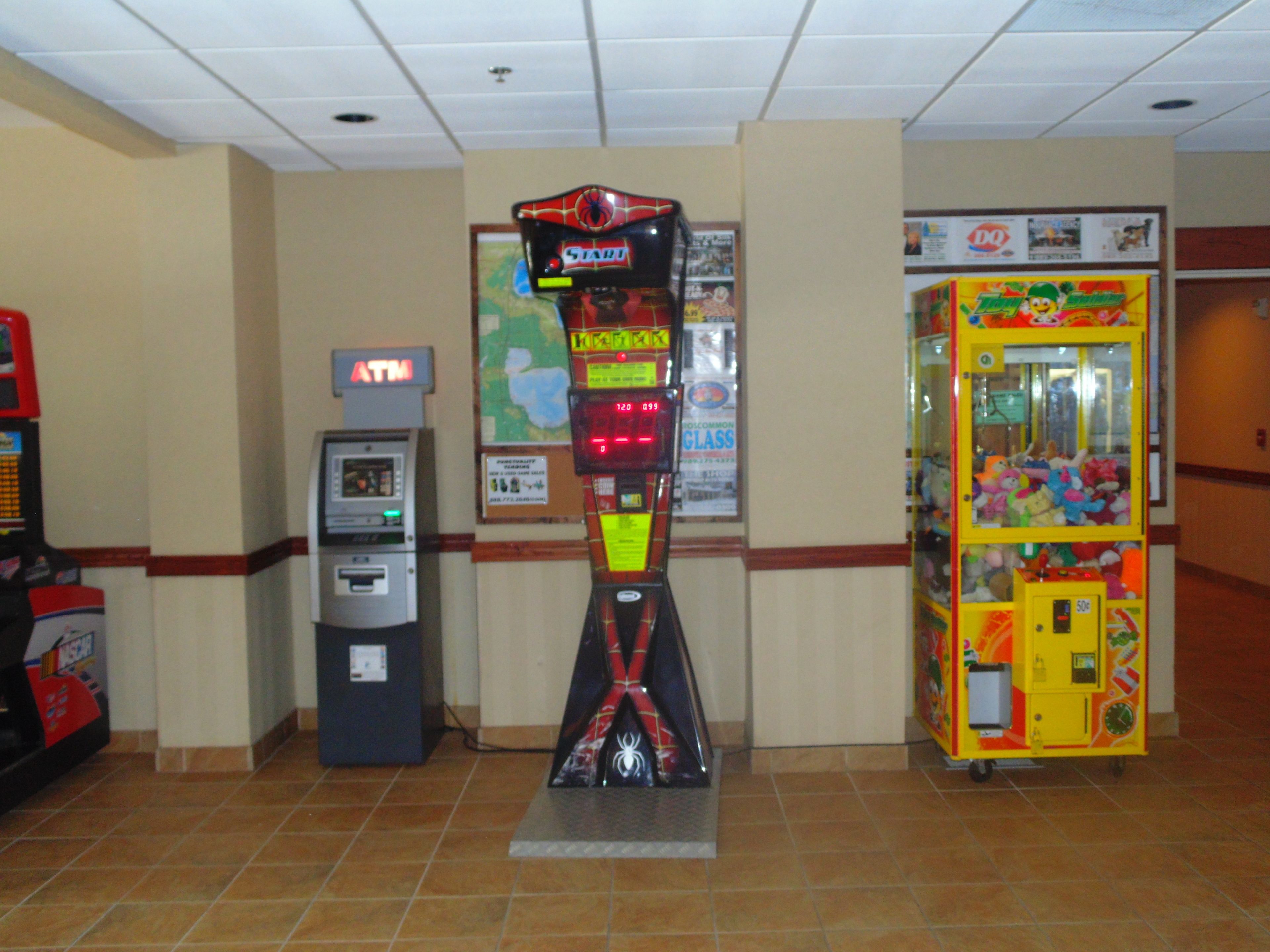An indoor setting with an ATM, a vending machine, and a Spider-Man themed game booth.