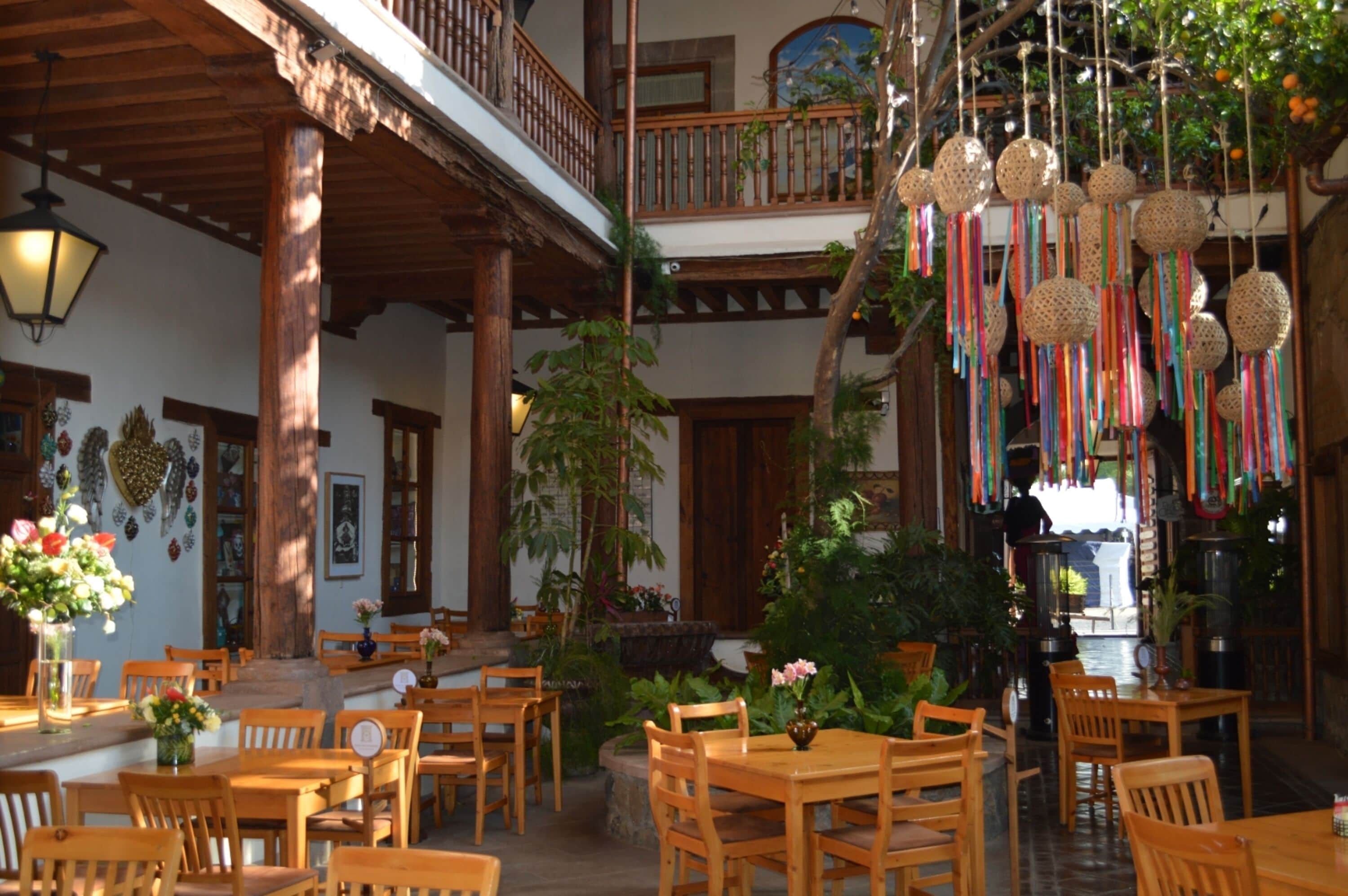 A traditional inn with wooden furniture, a balcony, and hanging decorative items.