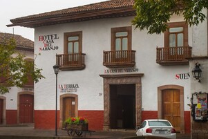 A building with a sign reading "Hotel Casa del Naranjo" and "La Terrazza Chocolates Sala de Cielo Repostería: Bocados y Lafe".