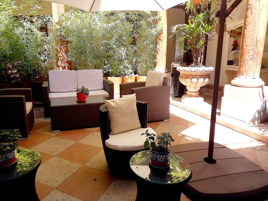 An outdoor seating area with wicker furniture and potted plants.