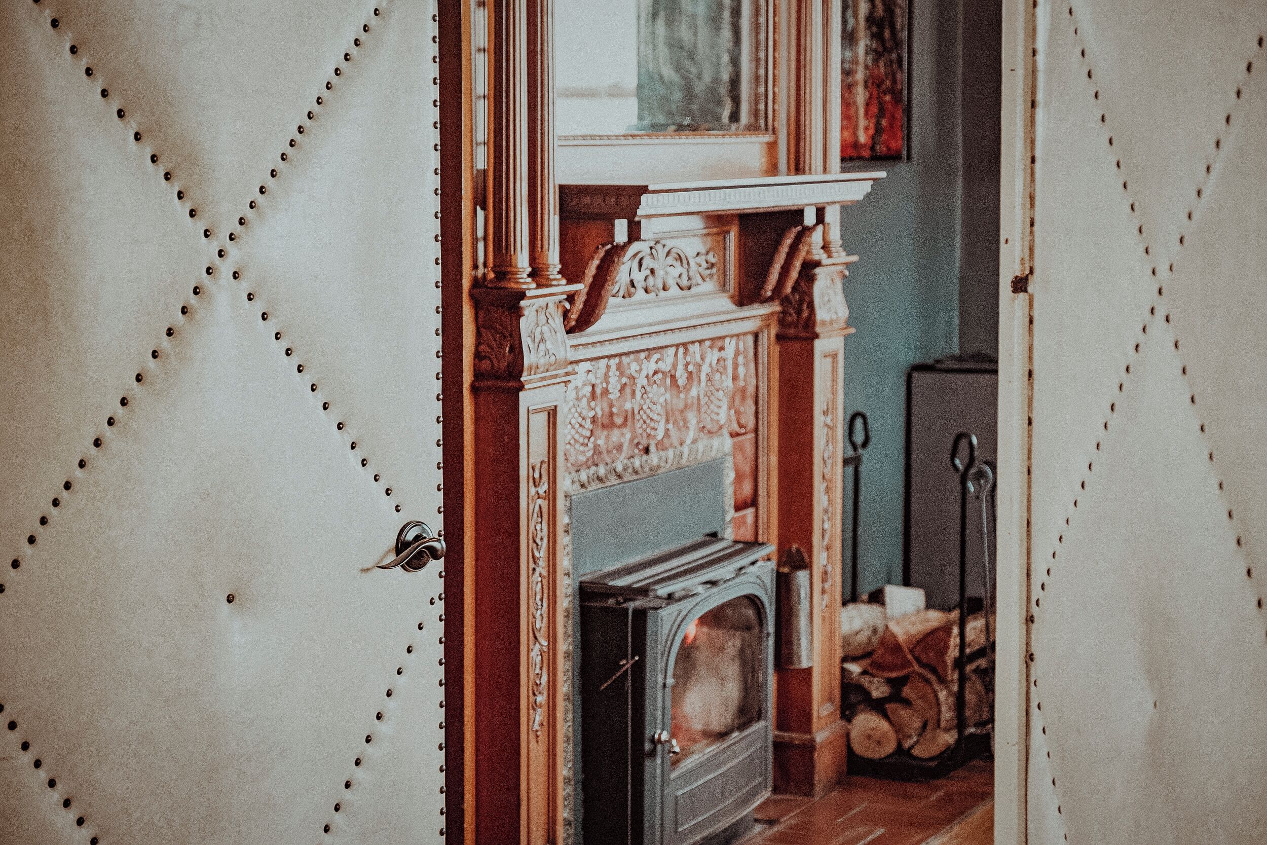 A room with a fireplace, a door with a handle, and a window.