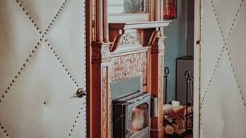 A room with a fireplace, a door with a handle, and a window.