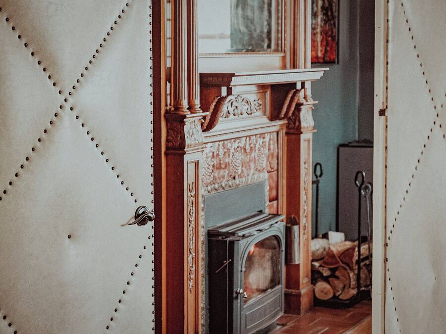 A room with a fireplace, a door with a handle, and a window.