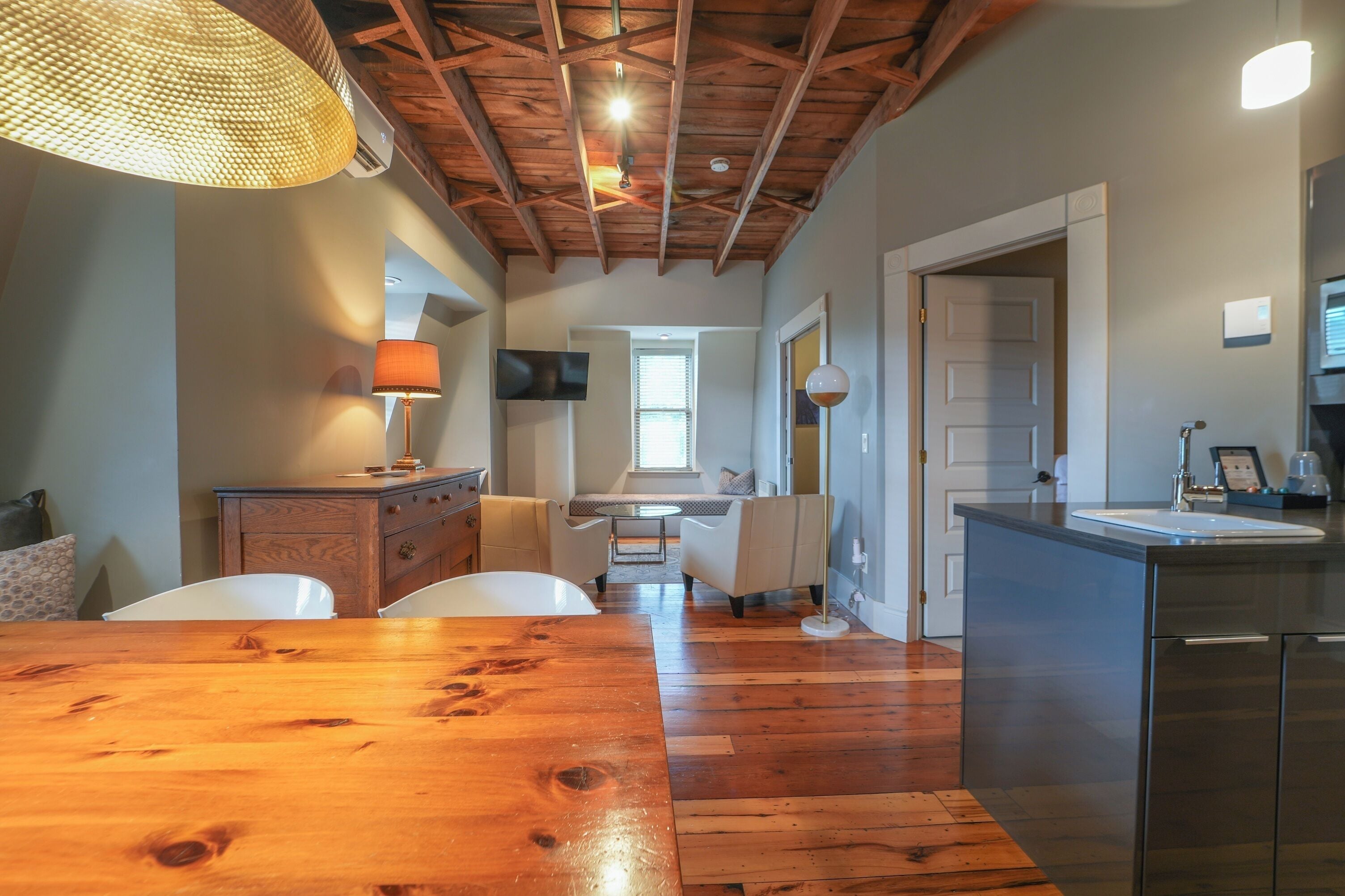 A spacious kitchen with a wooden dining table, a built-in oven, and a sink.