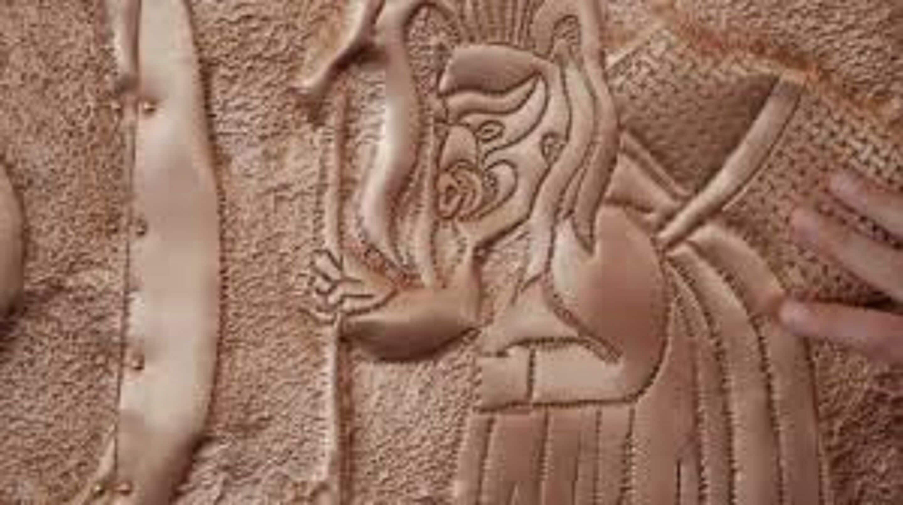 Un primo piano di una scultura di sabbia raffigurante una figura con uno scettro.