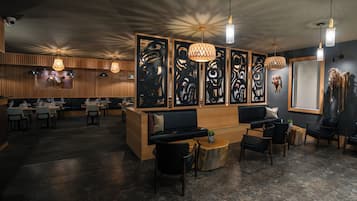 A modern interior with a reception desk, seating area, and dining space.