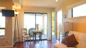 Suite, vista al océano | Área de sala de estar | Televisión de pantalla plana