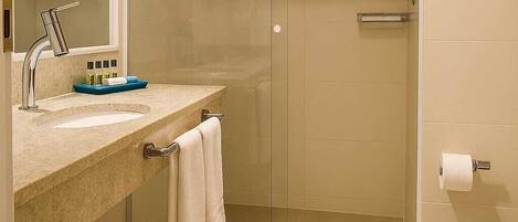 A modern bathroom with a glass shower enclosure, a sink with a mirror, and a toilet.
