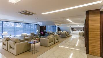 A spacious, modern lounge area with multiple seating options, large windows, and a clean, minimalist design.