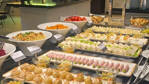 A buffet with various food items including salads, meats, and appetizers.
