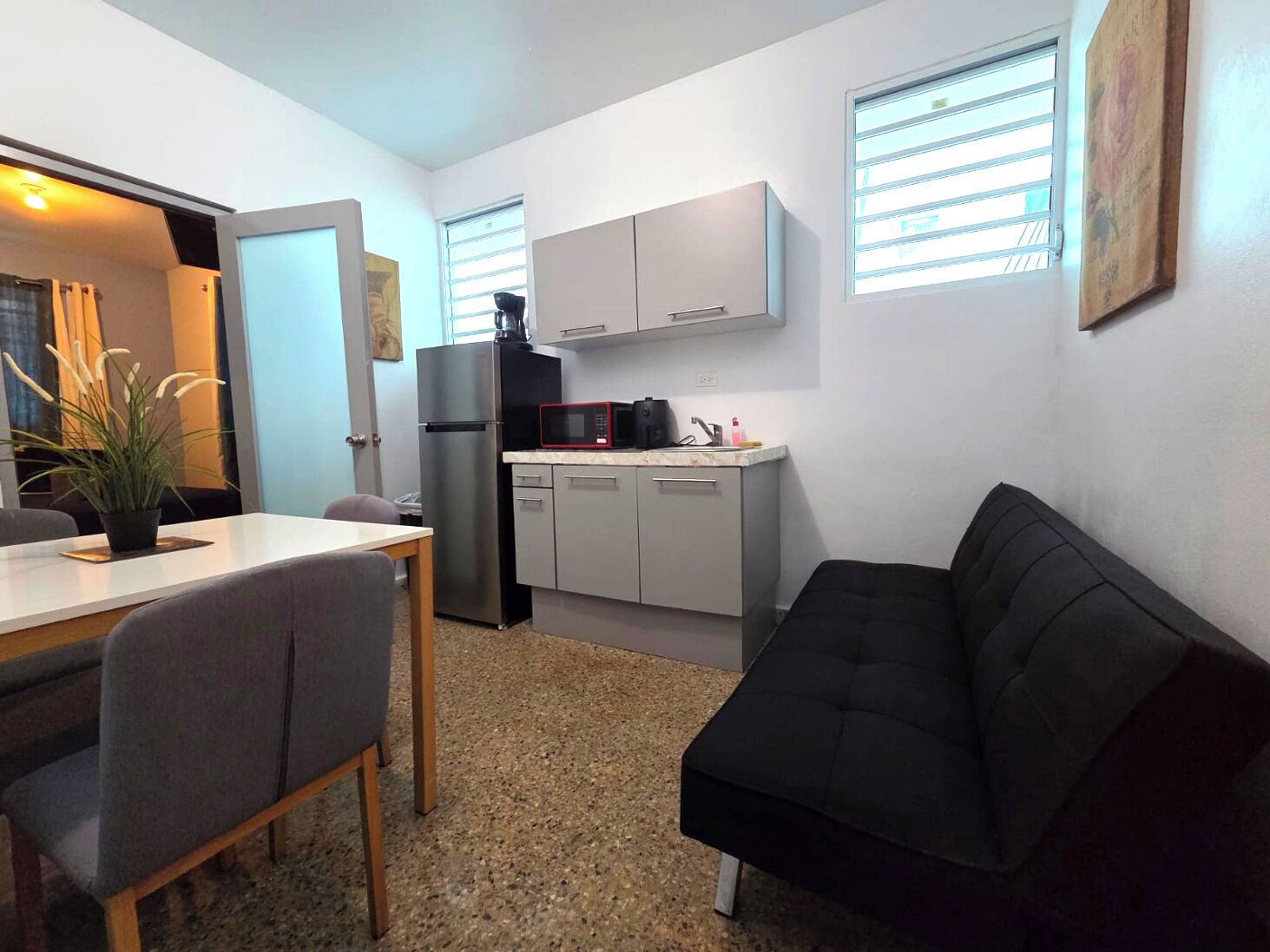 A compact living space with a kitchenette, a dining area, and a seating area.