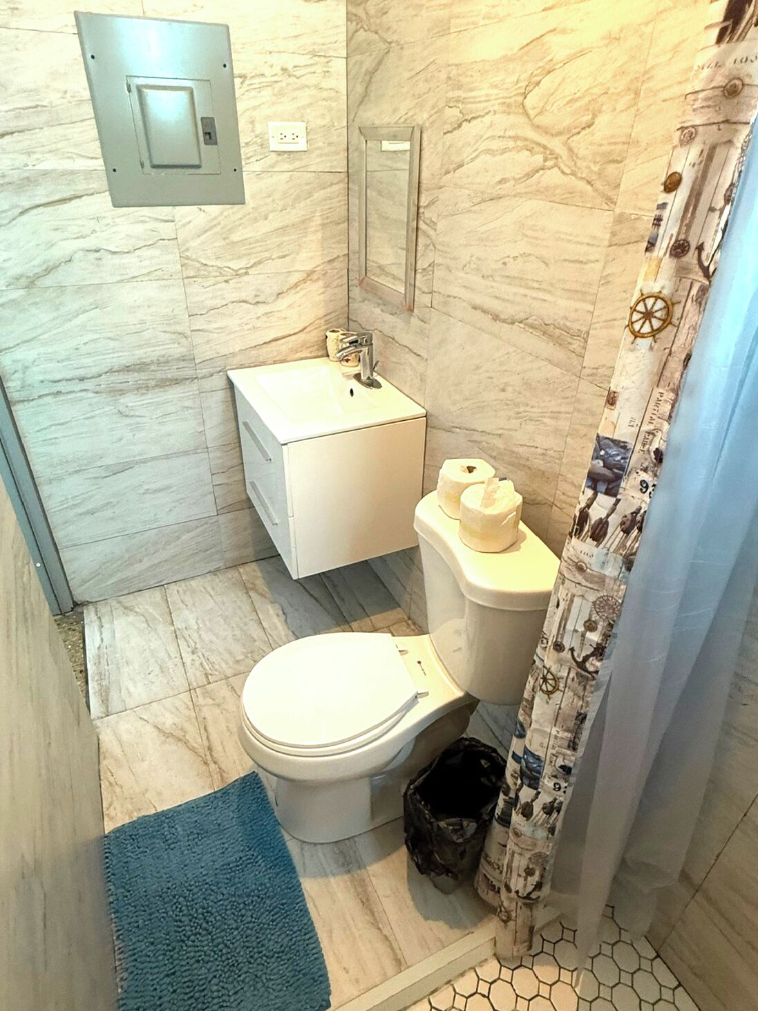 Un baño pequeño con inodoro, lavabo y cortina de ducha.