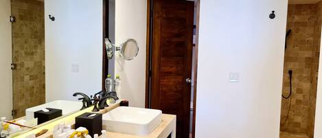 Une salle de bain moderne avec deux lavabos, un grand miroir et un espace douche.
