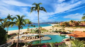 Un resort con piscina, playa y palmeras.