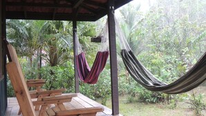 A wooden deck with benches and a hammock. - Yatama Ecolodge Sarapiqui (Las Horquetas)