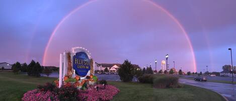 A sign for Blue Gate Garden Inn with a rainbow in the background.