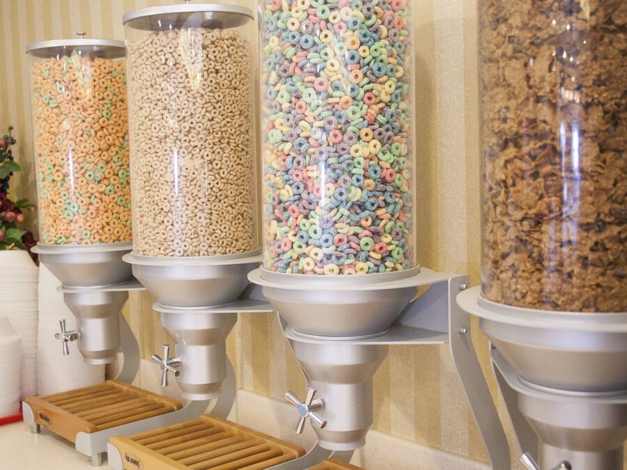 A cereal dispenser with multiple containers filled with different types of cereal.