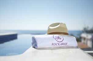 Una toalla blanca con un logotipo y la palabra "ROCKAWAY", sobre una superficie blanca con vista clara al océano.