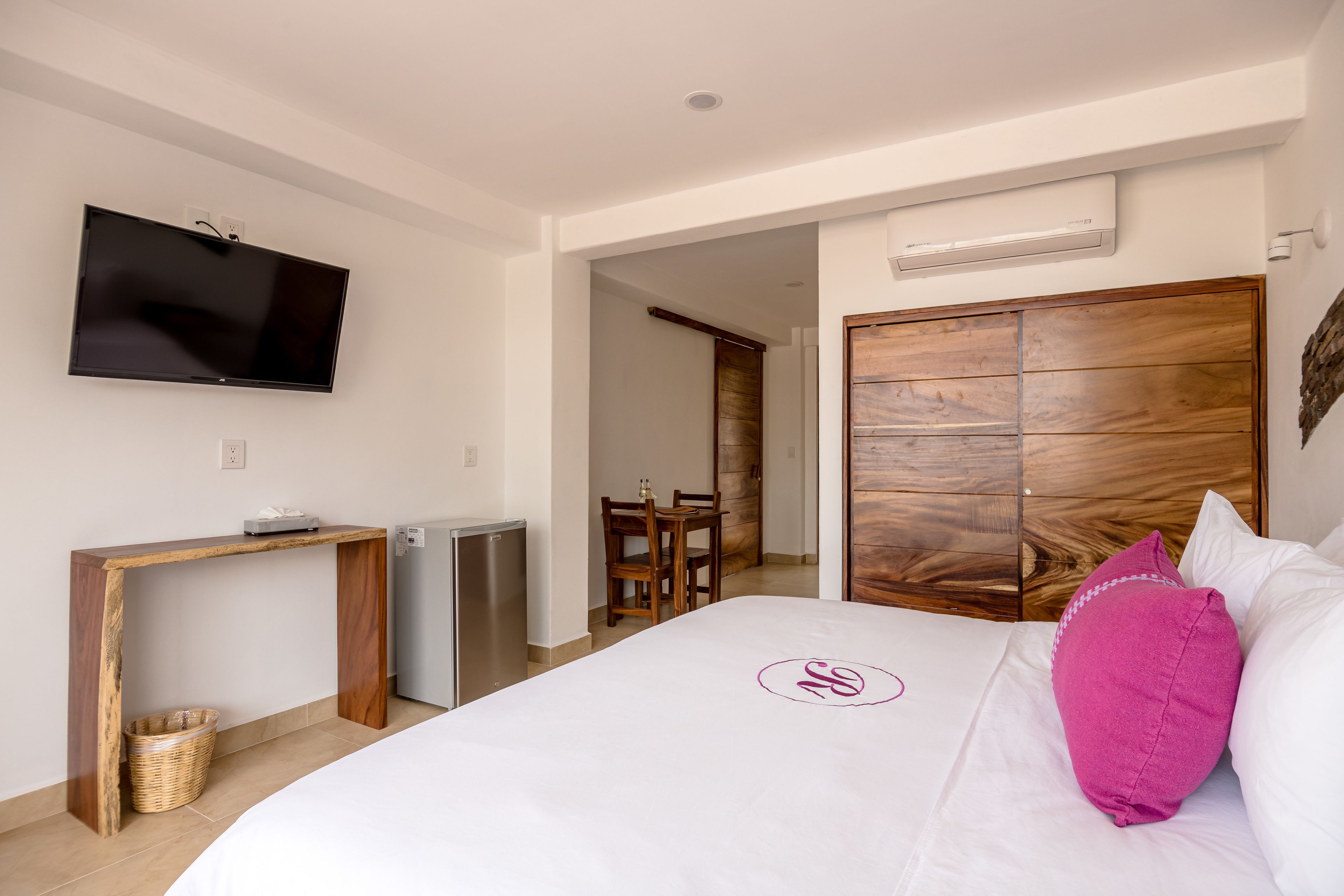 A hotel room with a bed, a desk, a television, and a wardrobe.