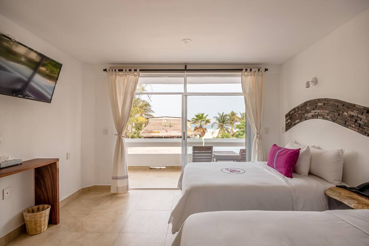 Habitación Deluxe, 2 camas matrimoniales, vista parcial al mar | Caja de seguridad en la habitación y tabla de planchar con plancha 