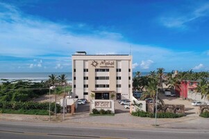 Hotel con vista al mar, varios pisos y un cartel que indica que es un hotel.