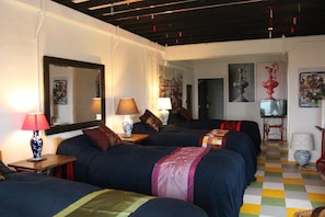 A hotel room with multiple beds, a large mirror, and artwork on the walls. - Shirahama Club (Minamiboso)