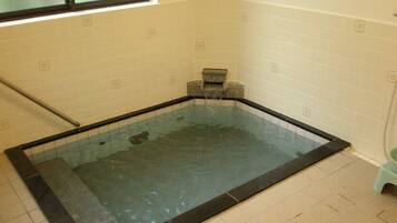 Relax in a hot tub with a glass bottom, surrounded by a tiled space.