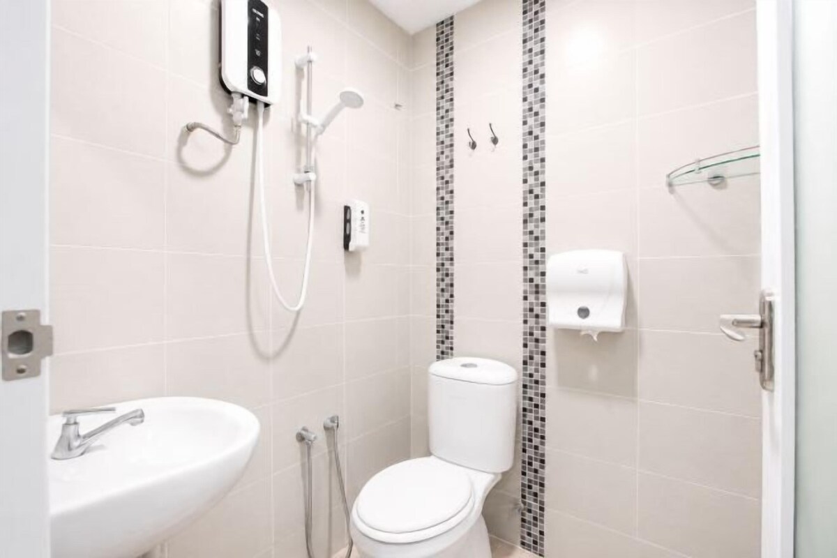 A bathroom with a white sink, toilet, and shower.