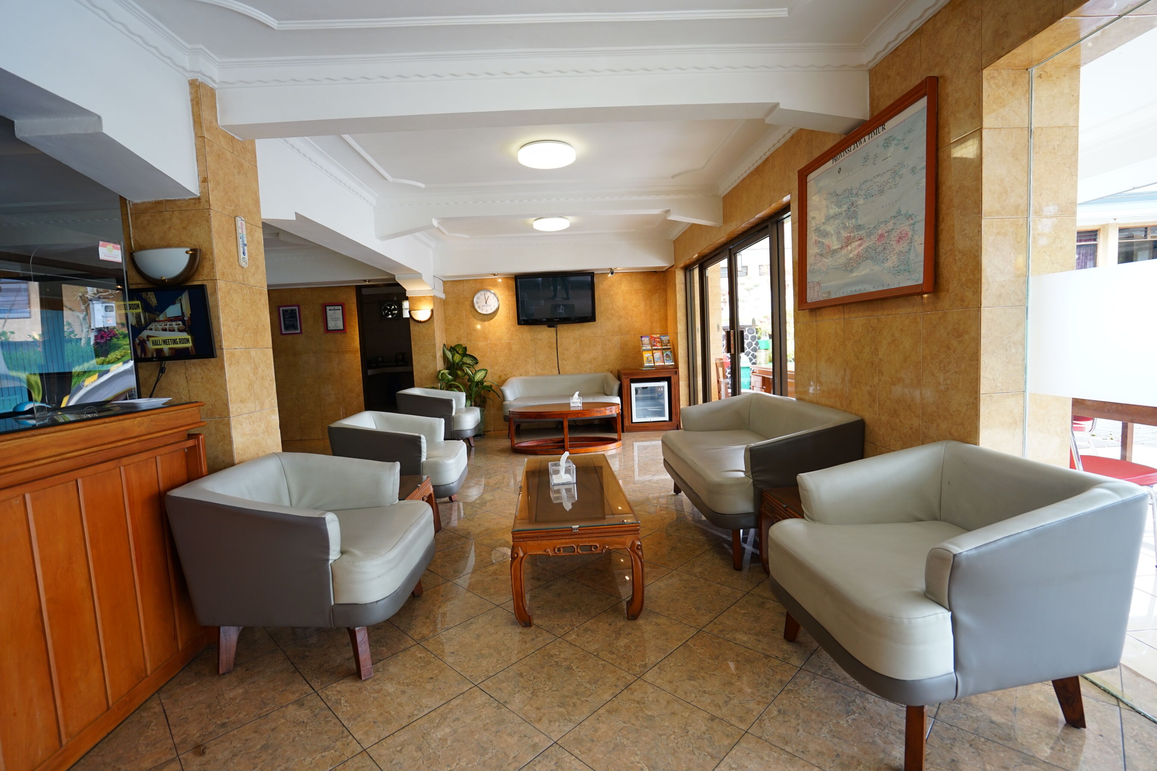 A lobby with a reception desk, seating area, and a television.