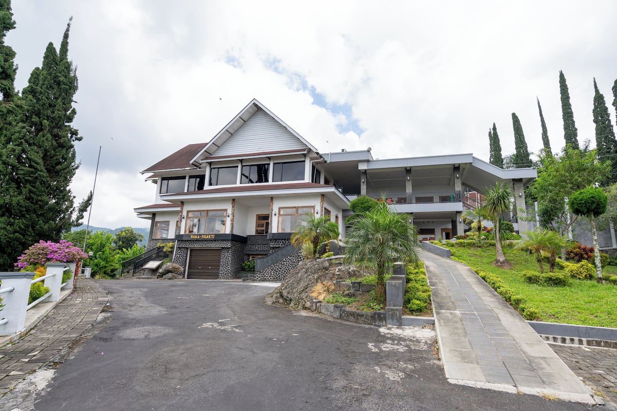 A two-story house with a stone facade and a balcony.