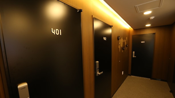 Un couloir d’hôtel avec des portes numérotées 401, 402 et 403.