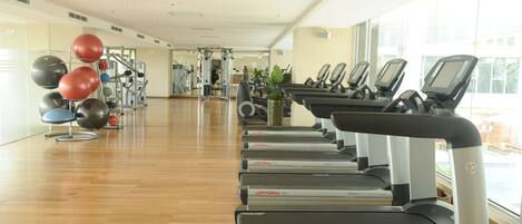 A gym with treadmills, exercise balls, and weight machines.