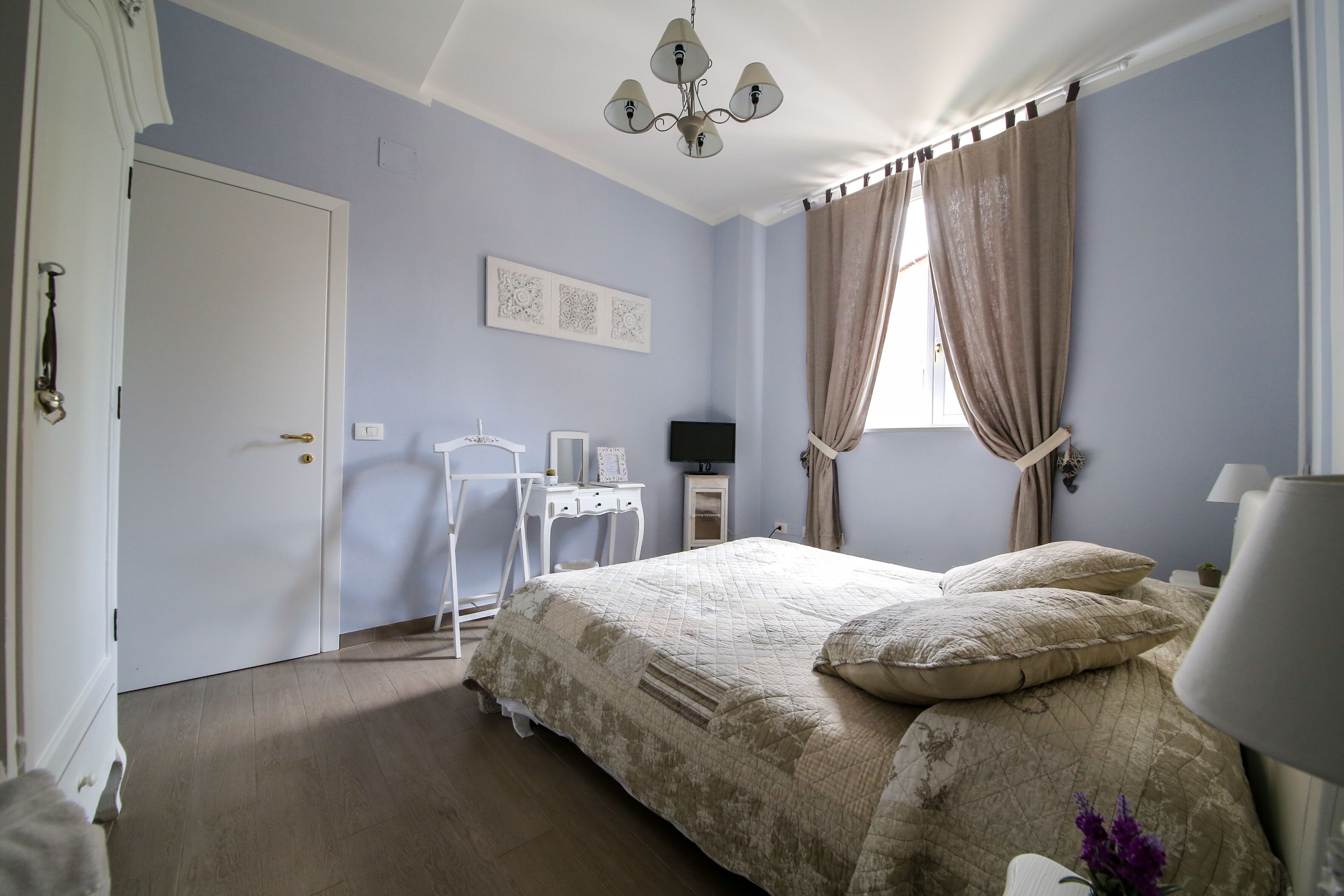 Un dormitorio con cama, escritorio y silla.