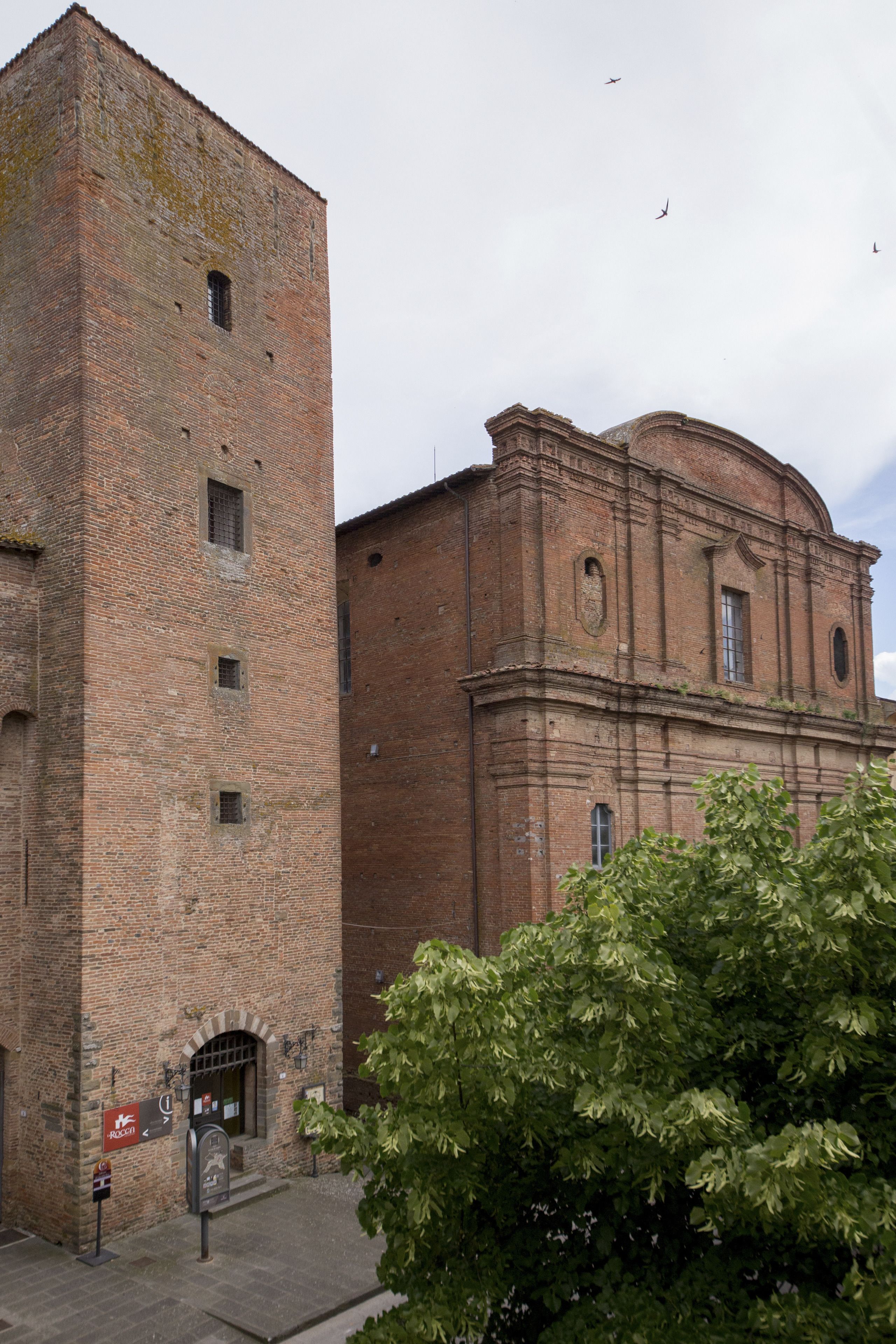 A historic building with a tall brick tower and a dome.