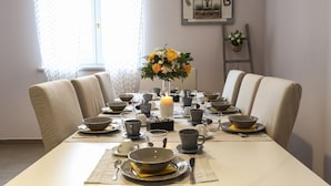 A dining table set with bowls, cups, and a candle centerpiece.