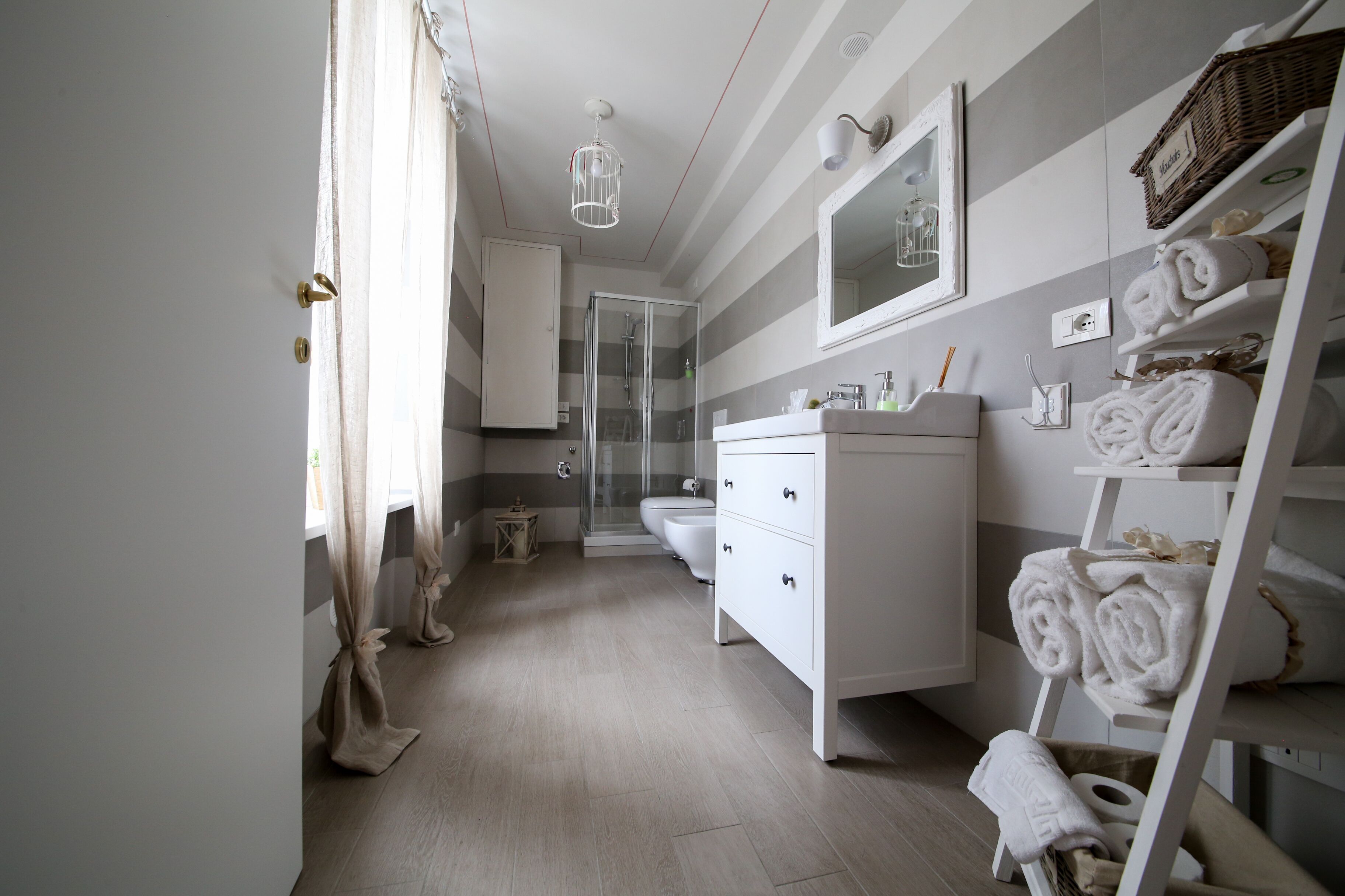 Een moderne badkamer met douche, toilet en wastafel.