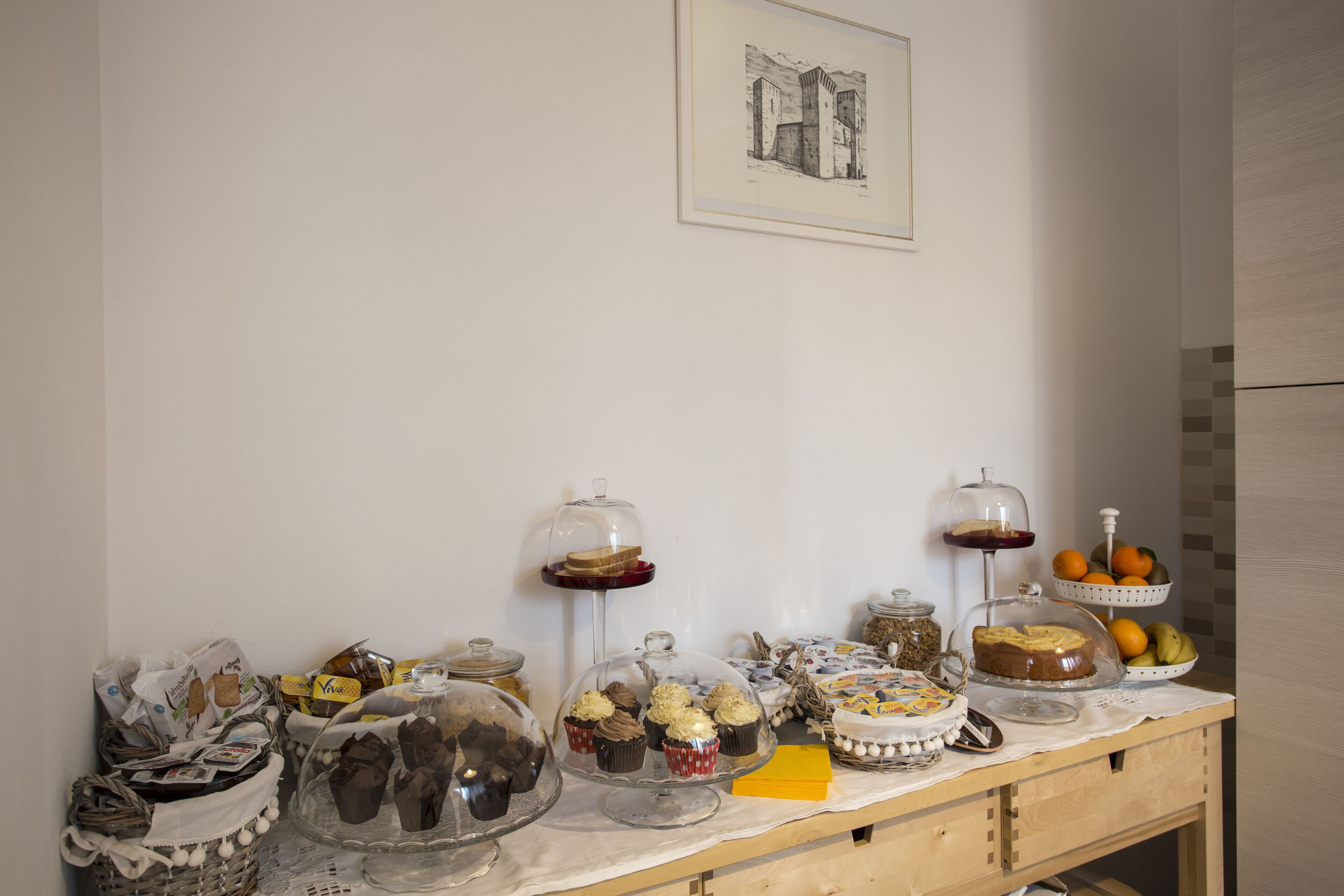 Una mesa de buffet con diversos alimentos y un cuadro en la pared.