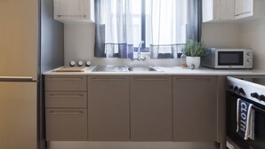 Een moderne keuken met een inbouwoven, magnetron en spoelbak.