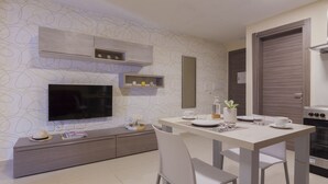 Een moderne keuken met een ingebouwde televisie, een eettafel met stoelen en een fornuis.