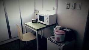 Eine kleine Küchenzeile mit einer Mikrowelle, einem Toaster und einer Kaffeemaschine auf einem Tisch.