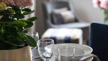 Una mesa puesta con platos, vasos y una planta en maceta.