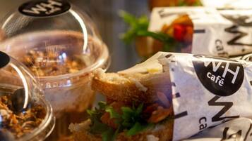 Un sándwich con ingredientes visibles y una etiqueta que dice 'W.H. cafe'.